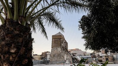 A view of the heavily damaged Al Hadba minaret seen through trees in Mosul. AFP