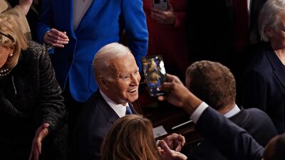 Mr Biden is greeted by members of Congress as he arrives to deliver the address. Bloomberg