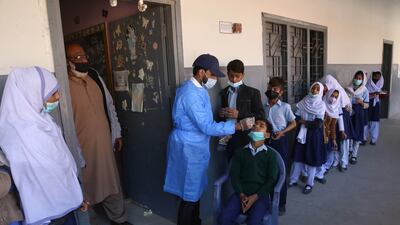 A health worker tests school pupils for Covid-19 during a surge in cases of Omicron in Karachi, Pakistan. The country has recorded more than 4,000 coronavirus cases for the second consecutive day. EPA