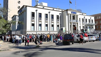 People queue outside a bank in Harare on Saturday. The country will soon introduce 'bond notes' to ease cash shortages. Aaron Ufumeli / EPA
