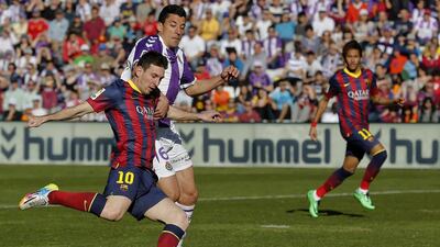 Barcelona’s Argentinian forward Lionel Mess, left, kicks the ball past Valladolid’s defender Jesus Rueda during the Spanish league football match Real Valladolid FC vs FC Barcelona at Jose Zorilla stadium in Valladolid on March 8, 2014. Cesar Manso / AFP