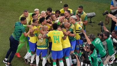 Brazil's Casemiro is mobbed by teammates after scoring. AP