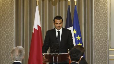 Sheikh Tamim delivers a speech before the official dinner, with flags of Qatar, France and the EU in the background. AFP