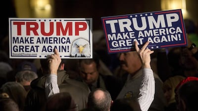 An attendee holds campaign signs for Donald Trump during a primary watch party in Manchester, New Hampshire. Trump re-assumed his frontrunner status in the Republican nominating contest. Victor J Blue / Bloomberg