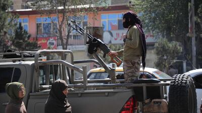 A Taliban fighter stands guard near the scene of the blast. AFP
