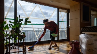 A woman cleans an apartment after strong winds from Typhoon Maysak left windows shattered, near Gwangalli beach in Busan. AFP