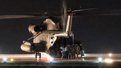 Released Israeli-US hostage Edan Alexander, surrounded by soldiers and family members, disembarks from an Israeli army helicopter. Reuters