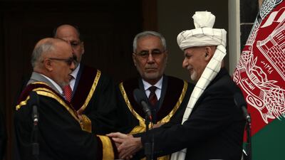 Afghan President Ashraf Ghani, right, shakes hands with Chief Justice Sayed Yousuf Halim. AP