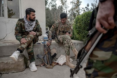 Kurdish fighters, members of The Organisation of Iranian Kurdistan Struggle (Sazmani Khabat), sit with their rifles at their base near Erbil. AFP
