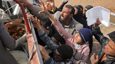 Iraqis displaced from the city of Mosul reach out to receive food aid at a camp in the Hamam Al Alil area south of the embattled city on March 11, 2017, during the government forces ongoing offensive to retake the area from ISIL. Ahmad Al Rubaye/AFP