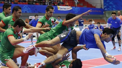 Lee Jang-kun of South Korea, in blue, is tackled by Iranian players during a kabbadi match at the 2014 Asian Games on Tuesday. Kim Kyung-hoon / Reuters / September 30, 2014