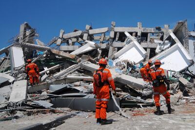 Members of an Indonesian rescue team look for survivors in a collapsed building in Palu. AFP