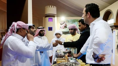 A group of men try out date juice at the festival.