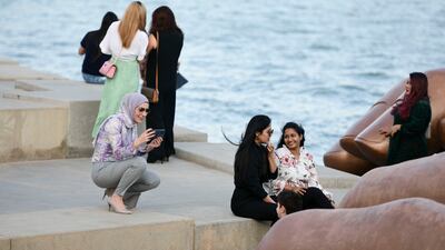 Visitors take photos near the giant sculpture.