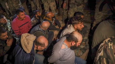 Alleged Syrian army soldiers and allied fighters sit on the floor after being captured by opposition fighters in Aleppo. AP