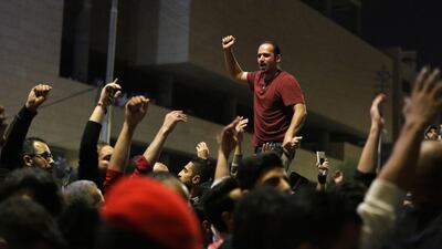 A protester leads the crowd to co-ordinate their anti-government chanting. Andre Pain / EPA