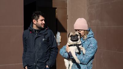 Samir Khuder, Anna Ponomaryova and their dog, Fedya, enjoy the fresh air after a night spent in the basement they used as a bomb shelter after a rocket hit a shopping mall in Kyiv. Getty