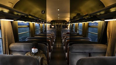 A man wearing a protective face mask sits in an almost-empty carriage of a train arriving in Paris on March 17, 2020. AFP