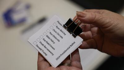 A woman holds ballot papers before Republican caucus voters arrive to choose a presidential candidate, in Silver City. Reuters
