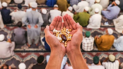 A Muslim man holds tabarrukat (blessed offerings) during prayers at the Hazratbal Shrine in Srinagar, Indian Kashmir. EPA