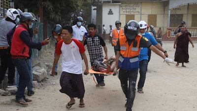 A wounded man is carried on a stretcher by a medical team after security forces opened fire on protesters during a demonstration against the military coup in Mandalay. AFP