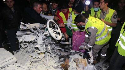 Lebanese emergency personnel inspect the wreckage of a minibus at the site of an explosion on February 3, 2014 in Choueifat, south of the capital Beirut. Str/AFP Photo