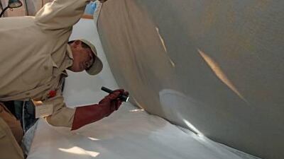 Arnel Rendon of National Pest Control inspects a bed for bedbugs. The creatures are becoming increasingly resistant to pesticides.
