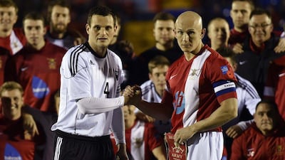 British Army football captain Sergeant Keith Emmerson, right, shakes hands with his German counterpart, Bundeswehr captain Alfred Hess, before their teams played the "Game of Truce" on Wednesday in Aldershot, England. Toby Melville / Reuters