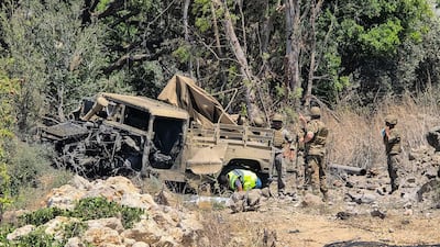 Lebanese soldiers at the site of strike on their vehicle in Al Mansouri, near Tyre, in southern Lebanon. AFP