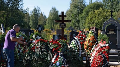 A man places flowers at Chekalov's grave. Reuters