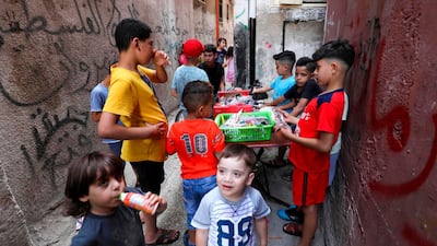 Palestinian children gather around a street vendor in the Amari refugee camp near the West Bank city of Ramallah. AFP