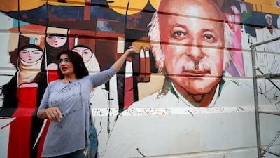 Iraqi artist Wijdan al-Majed draws a mural depicting Iraqi poet Muthaffar Al Nawab in Baghdad. AFP
