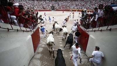 Mozos try to avoid the bulls as they enter the bullring. EPA