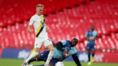 Mark Sykes of Oxford United is challenged by Adebayo Akinfenwa of Wycombe Wanderers. Getty