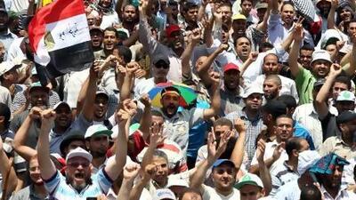 Activists hold placards with slogans of support yesterday for the Egyptian president Mohammed Morsi during a pro-government rally in Cairo. Khaled Elfiqi / EPA