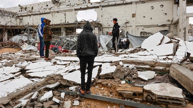 Palestinians look at the damage inside a war-damaged building, parts of which collapsed on a windy winter day in Gaza City on January 13, 2026. Since October 10, a fragile US-sponsored truce in Gaza has largely halted the fighting between Israeli forces and Hamas, but both sides have alleged frequent violations. (Photo by Omar AL-QATTAA / AFP)