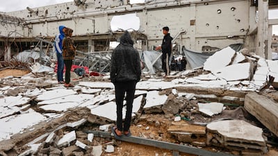 Palestinians look at the damage inside a war-damaged building, parts of which collapsed on a windy winter day in Gaza City on January 13, 2026. Since October 10, a fragile US-sponsored truce in Gaza has largely halted the fighting between Israeli forces and Hamas, but both sides have alleged frequent violations. (Photo by Omar AL-QATTAA / AFP)