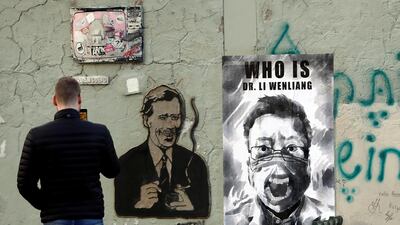 A man takes a picture of a poster of late Li Wenliang, a Chinese ophthalmologist who died of coronavirus at a hospital in Wuhan, in Prague, Czech Republic. Reuters