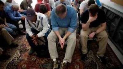Church volunteers bow their heads in prayer before delivering 225 gift bags to workers at a labour camp.