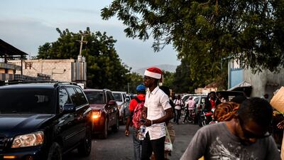 A man walks on the street wearing a Santa Claus hat during Christmas eve in Port-au-Prince. AFP