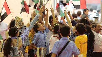 Children raise the UAE flag at Sharjah International Book Fair 2016. Courtesy NNC