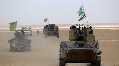 Armoured vehicles of Iraq's Iran-backed Popular Mobilisation Forces militias advance through Anbar province in the western desert bordering Syria on November 25, 2017. Ahmad Al Rubaye / AFP