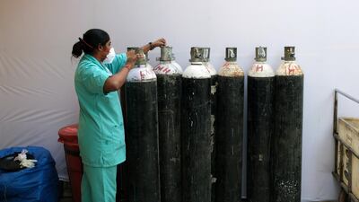 A health worker check oxygen cylinders at a makeshift Covid-19 quarantine facility set up in a banquet hall in New Delhi, India, April. Bloomberg