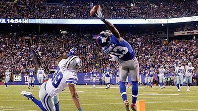 New York Giants wide receiver Odell Beckham Jr, right, makes a one-handed catch for a touchdown against Dallas Cowboys cornerback Brandon Carr in the second quarter of an NFL football game, Sunday, Nov. 23, 2014, in East Rutherford, N.J. (AP Photo/Julio Cortez)