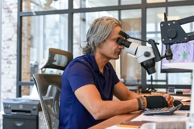 Tariq Riaz uses a big microscope, which has 30x magnification, to personally check each item before putting on the logo. Khushnum Bhandari / The National