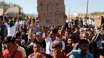 A migrant holds a placard as refugees and migrants take part in a demonstration against living conditions at the Moria camp on the island of Lesbos, Greece REUTERS