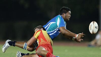 Clendon Pene of Abu Dhabi offloads the ball in the tackle. Francois Nel / Getty Images