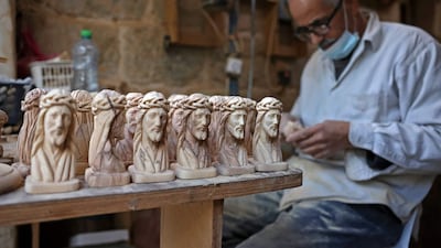 A Palestinian artisan makes statues from olive wood for Christmas. AFP