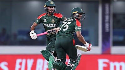 Bangladesh's Shakib Al Hasan (R) and teammate Mohammad Naim run between the wickets during the ICC men's Twenty20 World Cup cricket match between Oman and Bangladesh at the Oman Cricket Academy Ground in Muscat on October 19, 2021. (Photo by Haitham AL-SHUKAIRI / AFP)