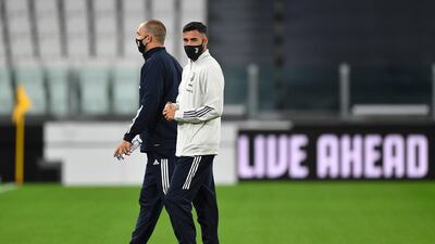 Juventus player Gianluca Frabotta and assistant coach Igor Tudor walk out onto the pitch ahead of the game. Getty Images